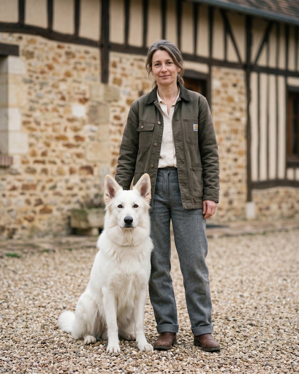 Claire Vasseur, éleveuse de berger blanc suisse, debout dans la cour de la longère